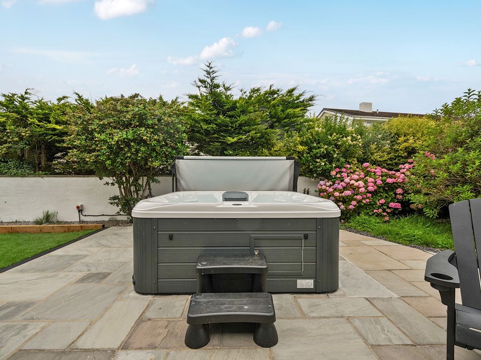A garden with a hot tub and steps at Seaddler in Trearddur Bay