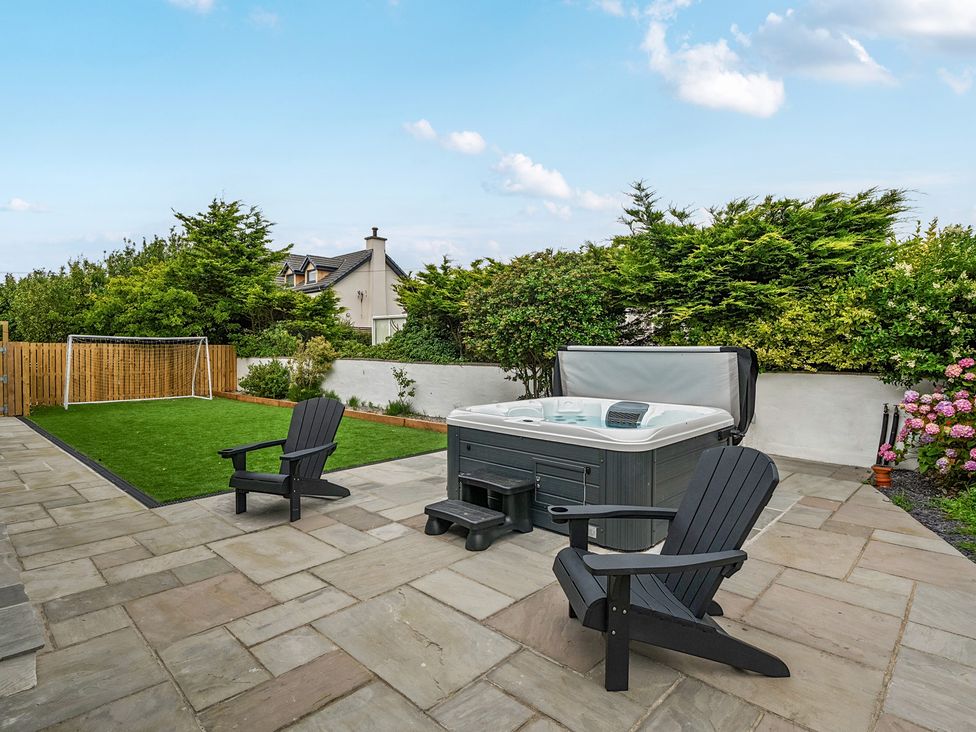 A garden with a hot tub and lawn at Seaddler in Trearddur Bay