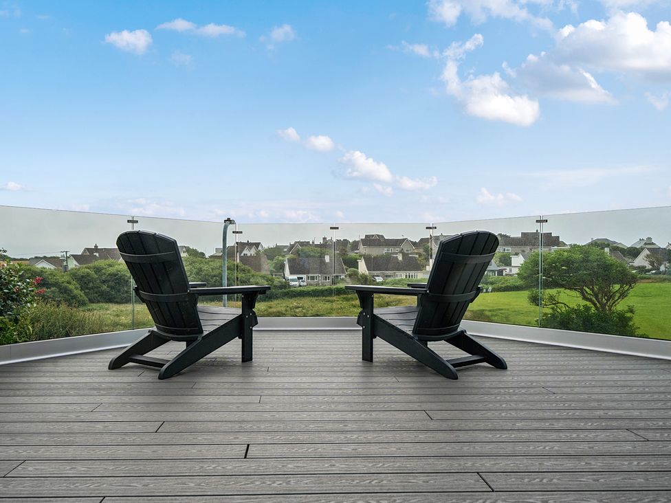 A balcony with chairs overlooking a landscape at Seaddler in Trearddur Bay