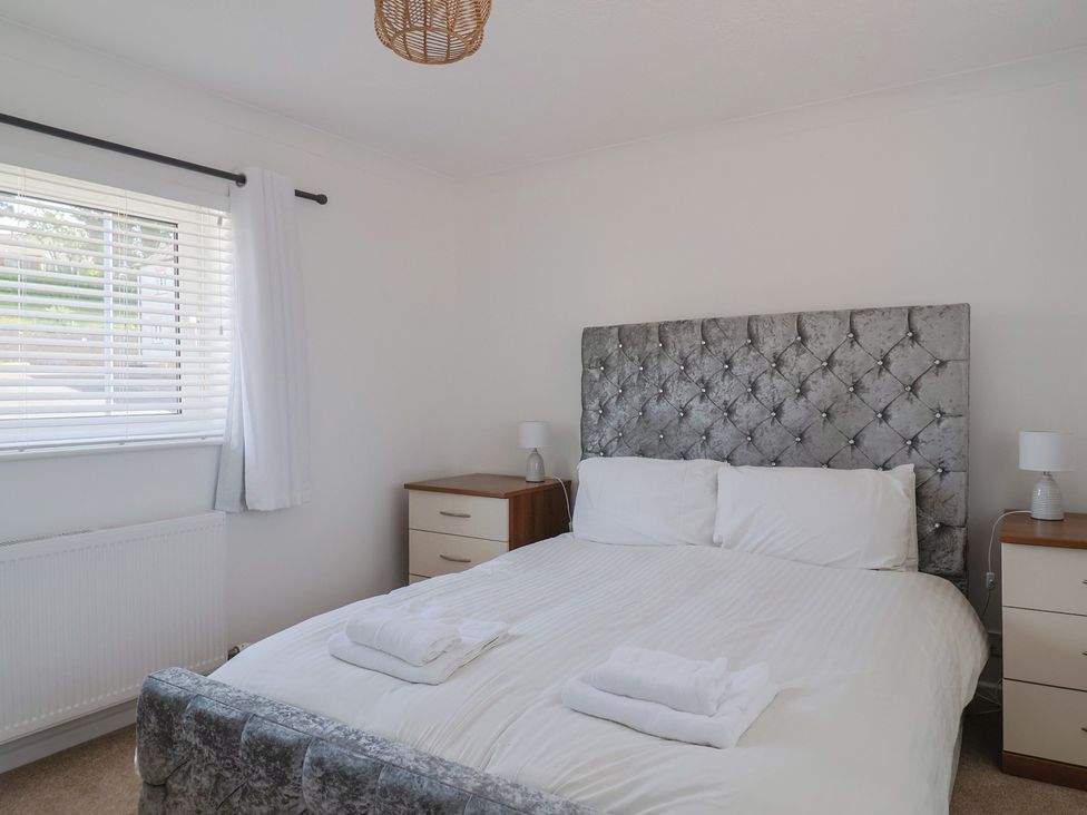 A bedroom with a bed with white bedding and two bedside tables with lamps at SubLyme in Lyme Regis