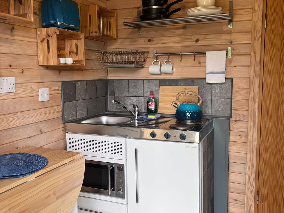A kitchen with a sink and stove at Lakeside Pods - pets welcome in Greenfield