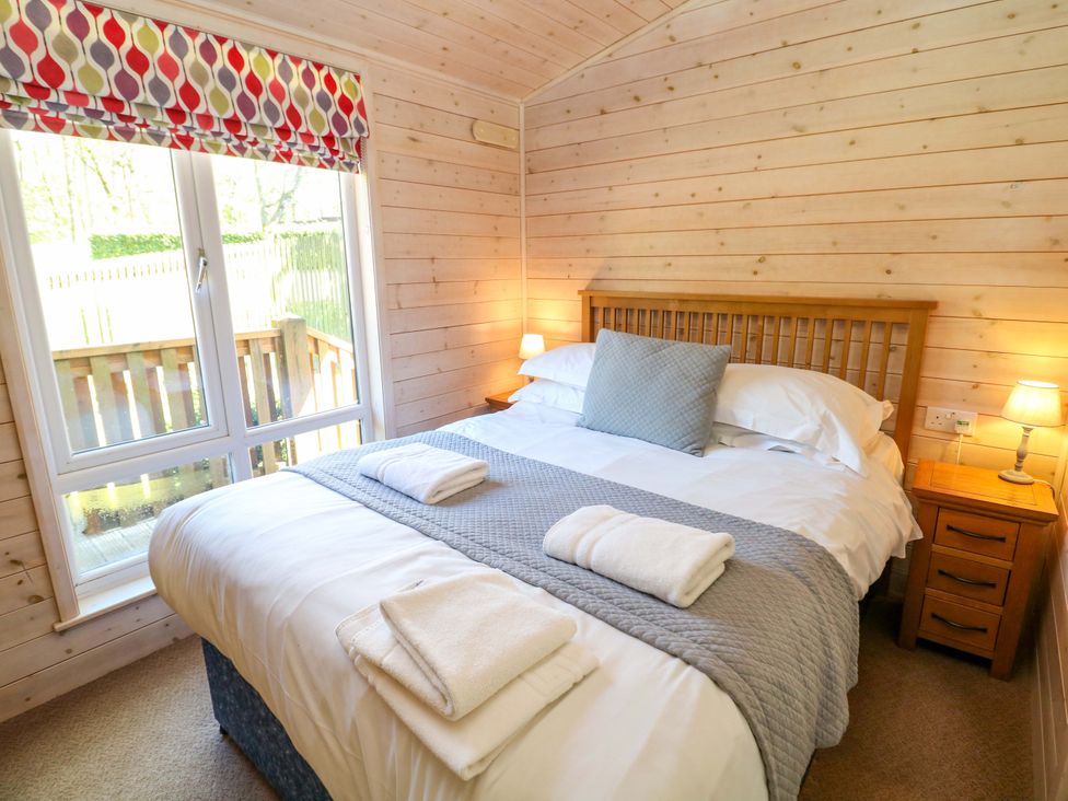 A bedroom with a double bed and a bedside table at Dovestone Luxury Lodges (sleeps 4)- pet free Greenfield