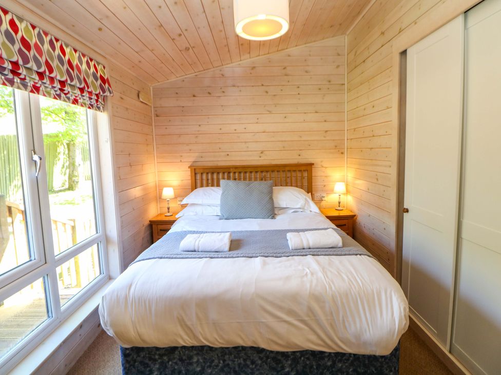 A bedroom with a double bed and bedside furniture at Dovestone Luxury Lodges (sleeps 4)- pet free, Greenfield