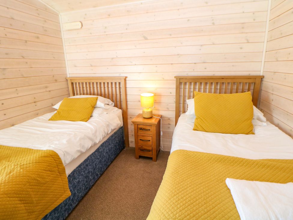 A bedroom with two beds and a nightstand at Dovestone Luxury Lodges (sleeps 4)- pet free, Greenfield