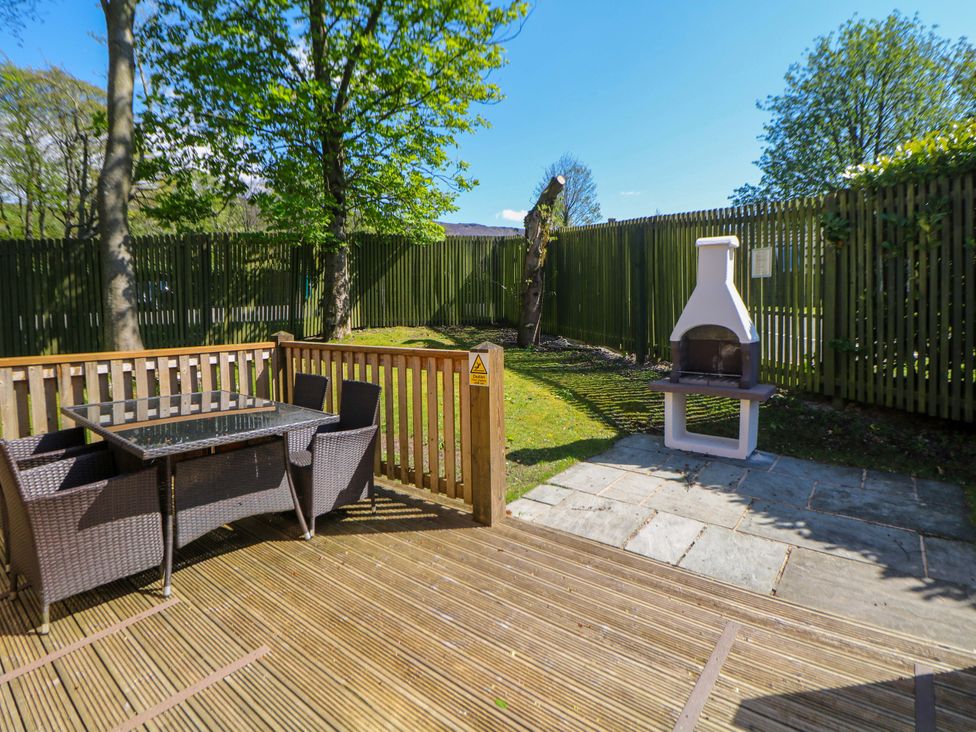 A garden area with outdoor seating and fireplace at Dovestone Luxury Lodges (sleeps 4)- pet free Greenfield
