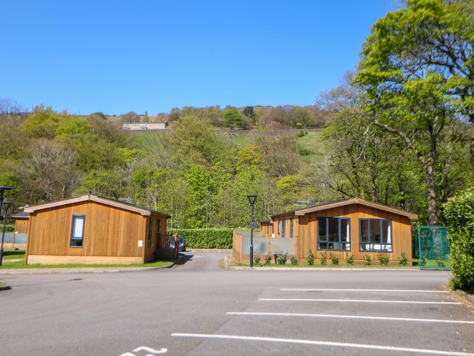 Two wooden lodges in an outdoor setting at Dovestone Luxury Lodges (sleeps 4)- pet free in Greenfield