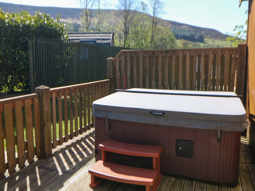 An outdoor area with a hot tub and wooden fence at Dovestone Luxury Lodges (sleeps 4) - pets welcome Greenfield