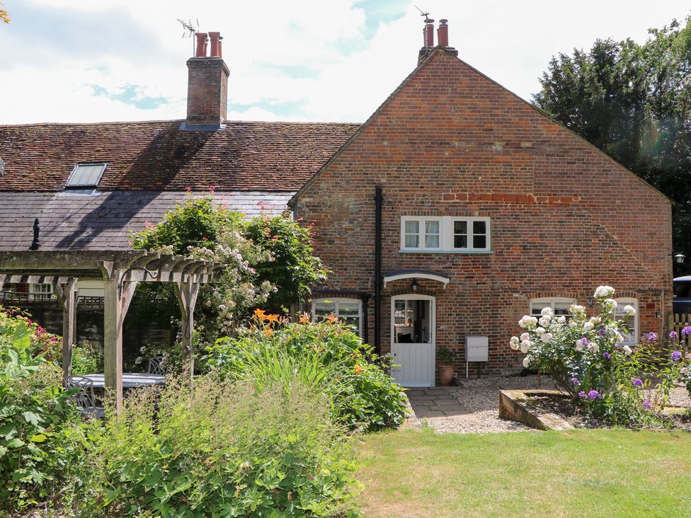 A brick house with a garden and flowers at 3 Malthouse Cottages Chawton near Alton