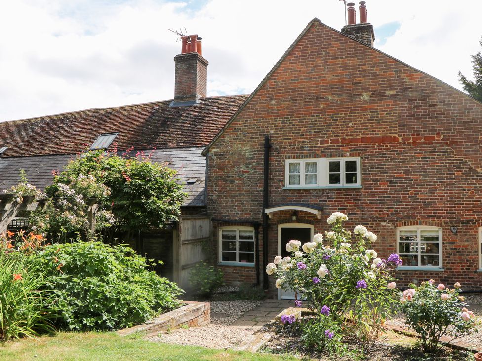 A brick house with flowers and a pathway at 3 Malthouse Cottages Chawton near Alton