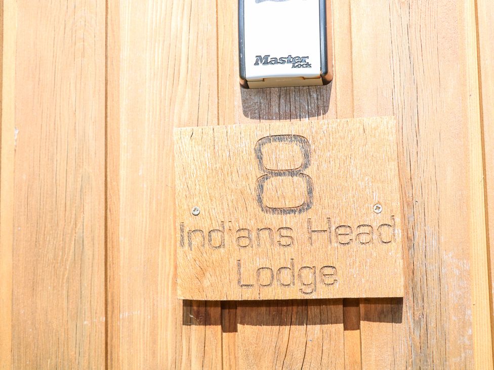 A door with a wooden sign displaying the number 8 and the name Indians Head Lodge