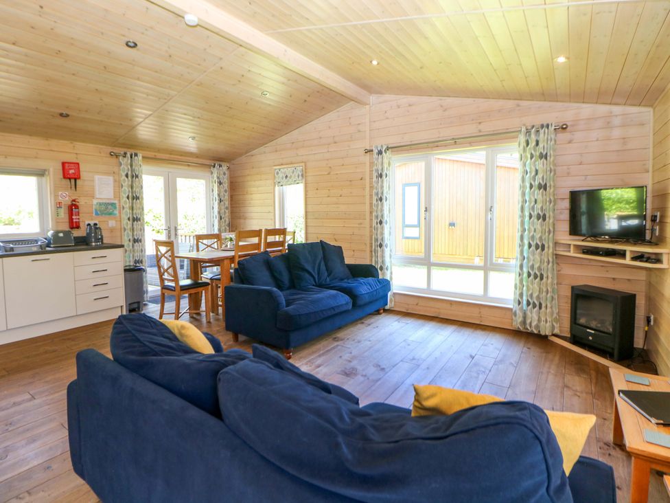 A living room with a couch and dining table at Dovestone Luxury Lodges (sleeps 6) - pet free, Greenfield