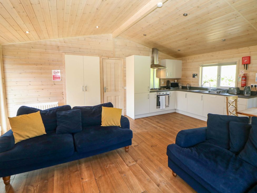 A living room with a kitchen area at Dovestone Luxury Lodges (sleeps 6) - pet free Greenfield