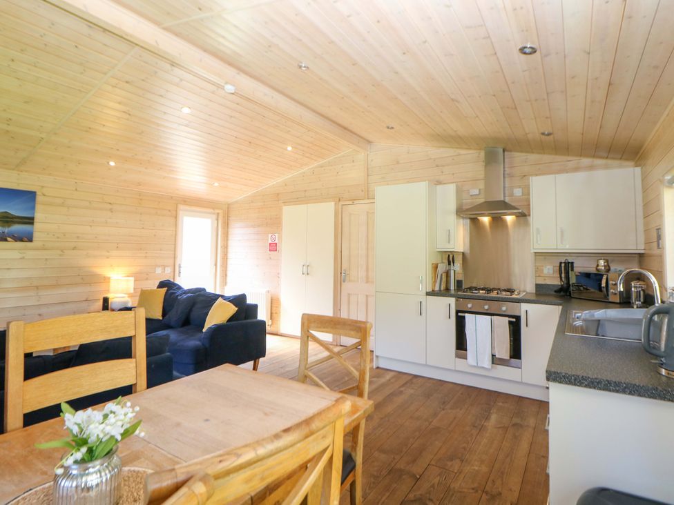 A living room with a sofa and kitchen units at Dovestone Luxury Lodges (sleeps 6) - pet free, Greenfield
