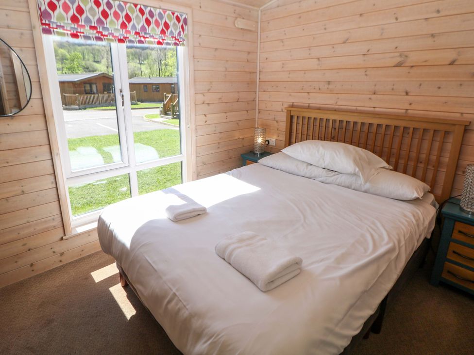 A bedroom with a bed and window at Dovestone Luxury Lodges (sleeps 6) - pet free, Greenfield