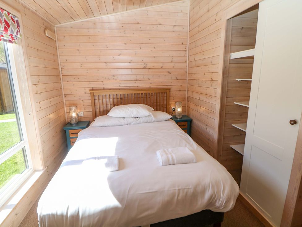 A bedroom with a bed and nightstand at Dovestone Luxury Lodges (sleeps 6) - pet free Greenfield