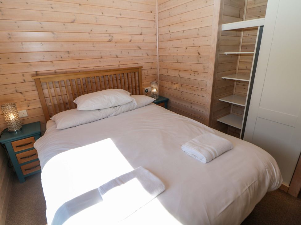 A bedroom with a bed and bedside table at Dovestone Luxury Lodges (sleeps 6) - pet free, Greenfield