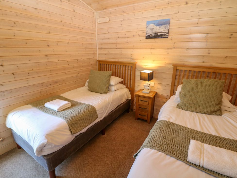 A bedroom with two single beds and a bedside table at Dovestone Luxury Lodges (sleeps 6) - pet free, Greenfield