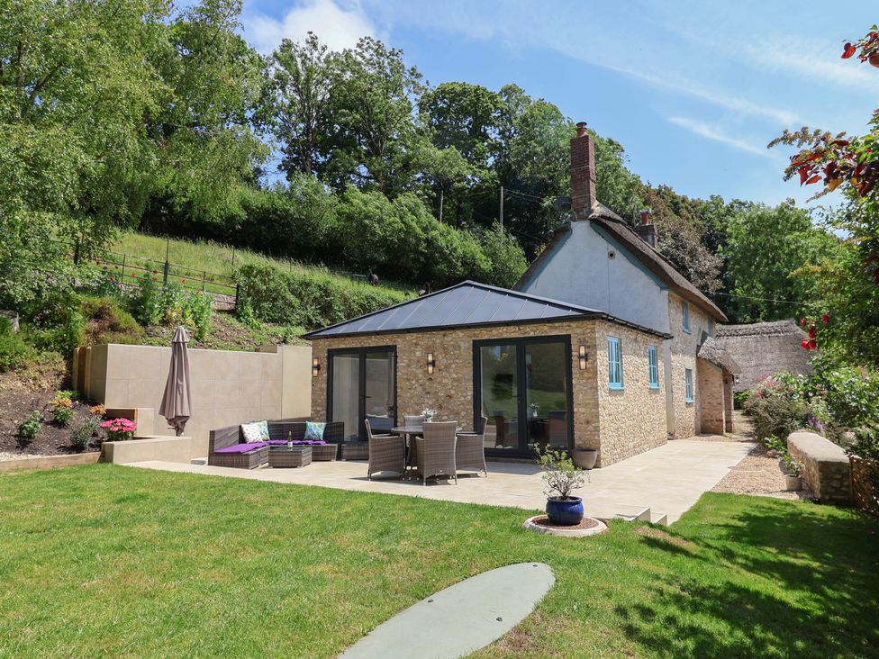 An outdoor seating area with a house at Upper Cottage Rocombe near Uplyme