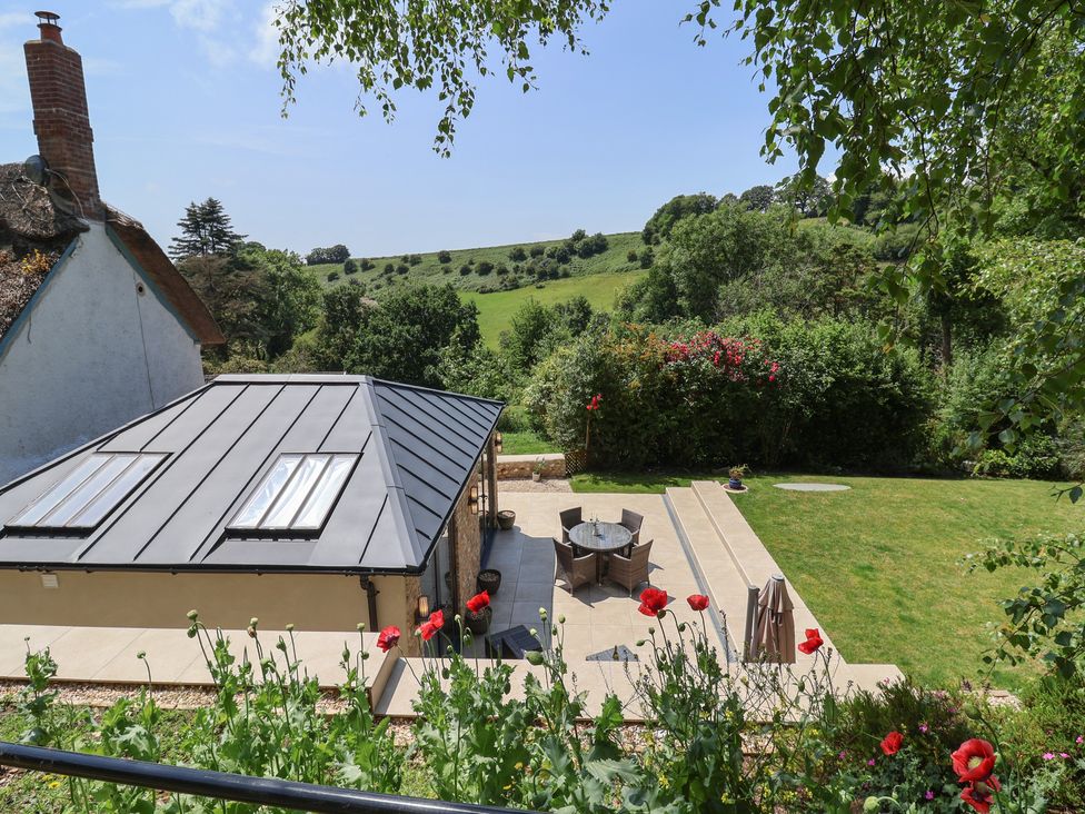 A garden with a table and chairs at Upper Cottage in Rocombe near Uplyme