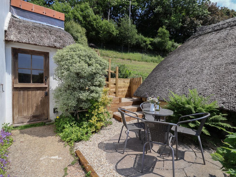 An outdoor area with a table and chairs at Upper Cottage in Rocombe near Uplyme