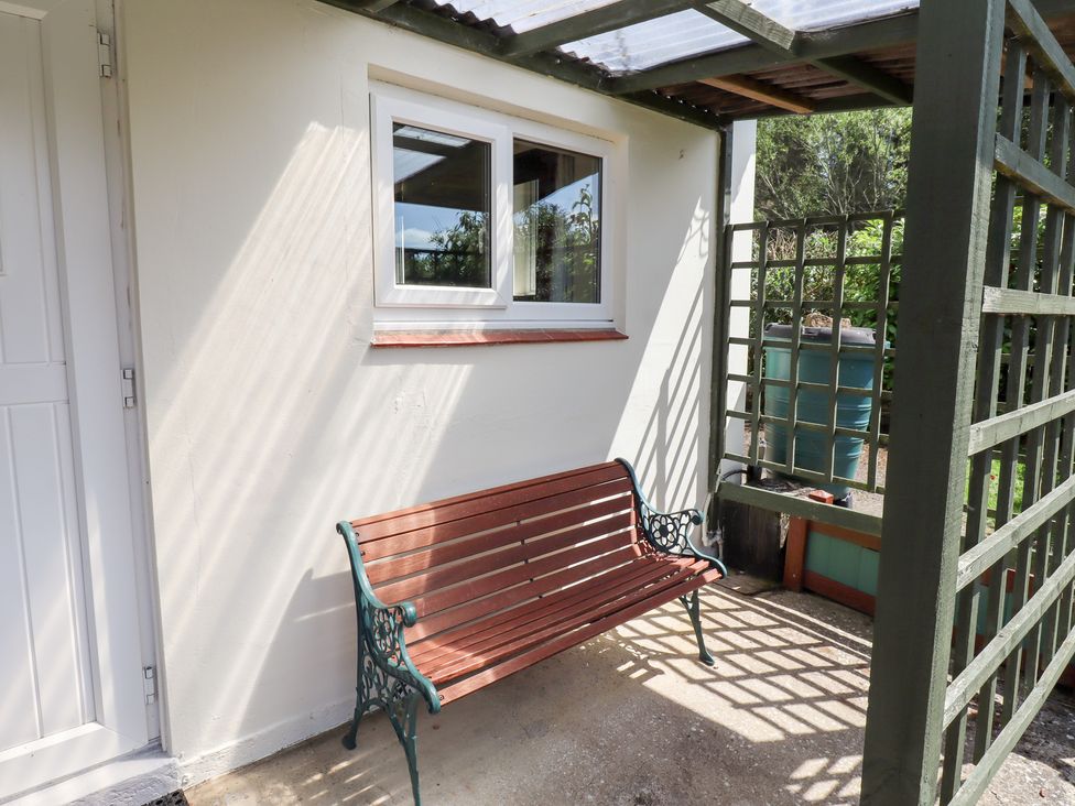 An outdoor area with a bench and a window at Fir Tree Cottage Cottonshopeburnfoot near Otterburn