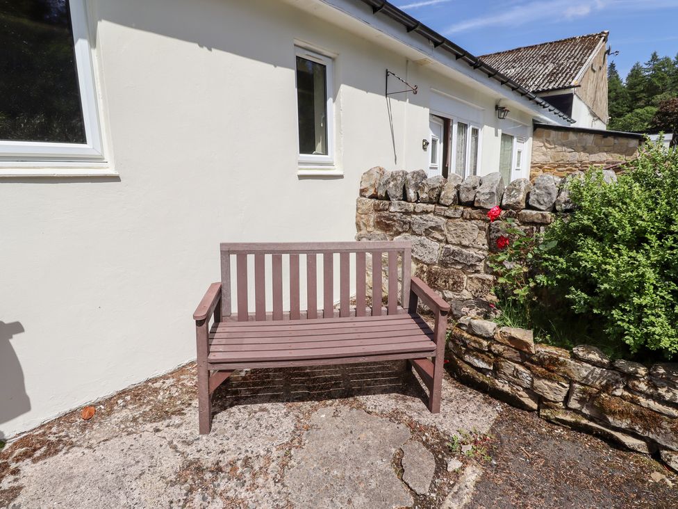 A bench in front of a house at Fir Tree Cottage Cottonshopeburnfoot near Otterburn