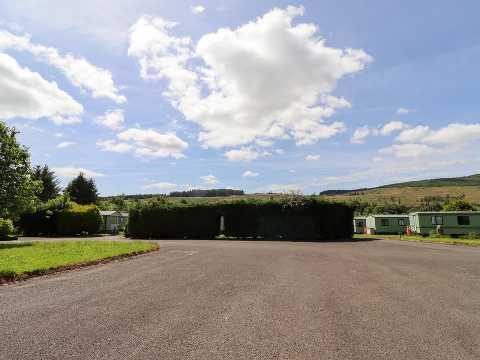 An outdoor view of caravans and grass at Fir Tree Cottage Cottonshopeburnfoot near Otterburn