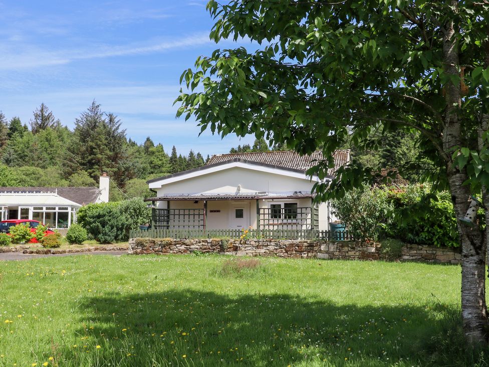 A house with a garden and trees at Fir Tree Cottage Cottonshopeburnfoot near Otterburn