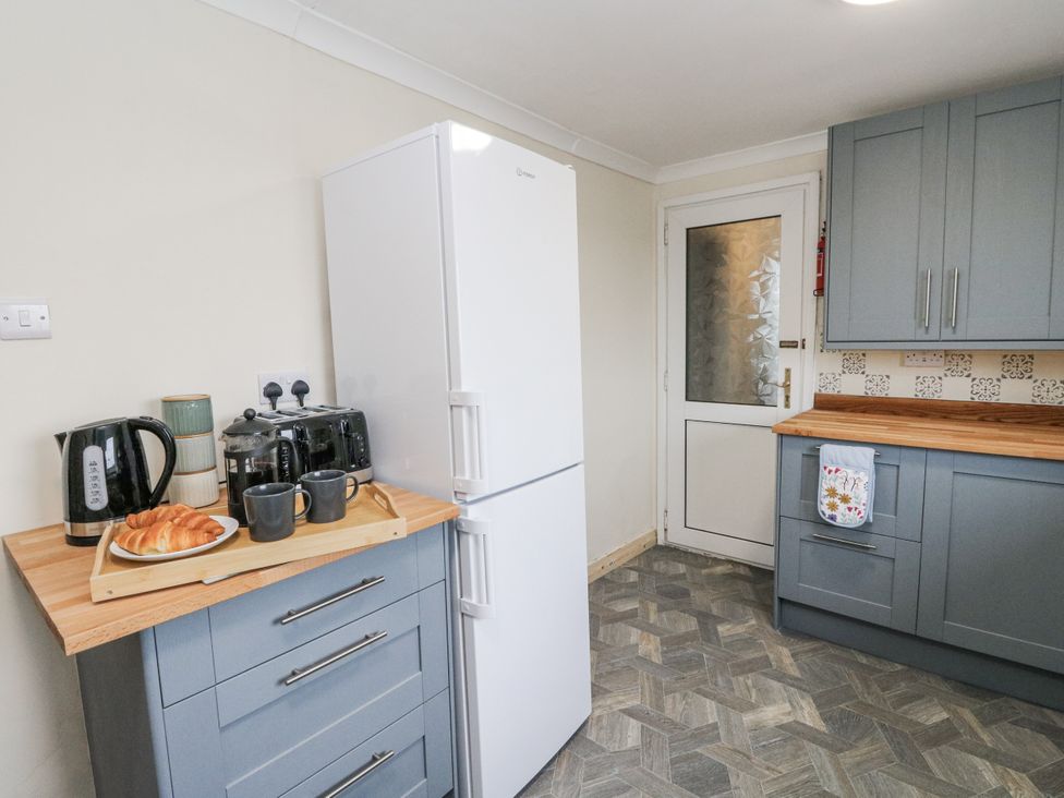 A kitchen with appliances and food items at Daisy Cottage in Wigton