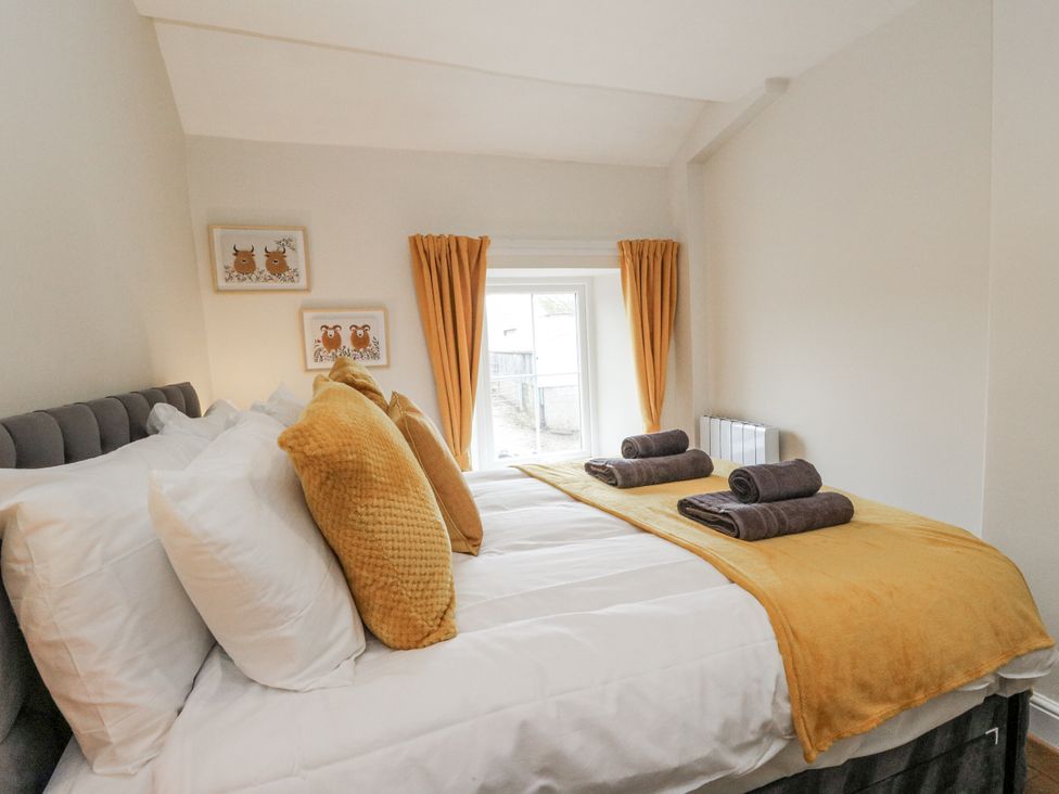 A bedroom with a bed and pillows at Daisy Cottage in Wigton