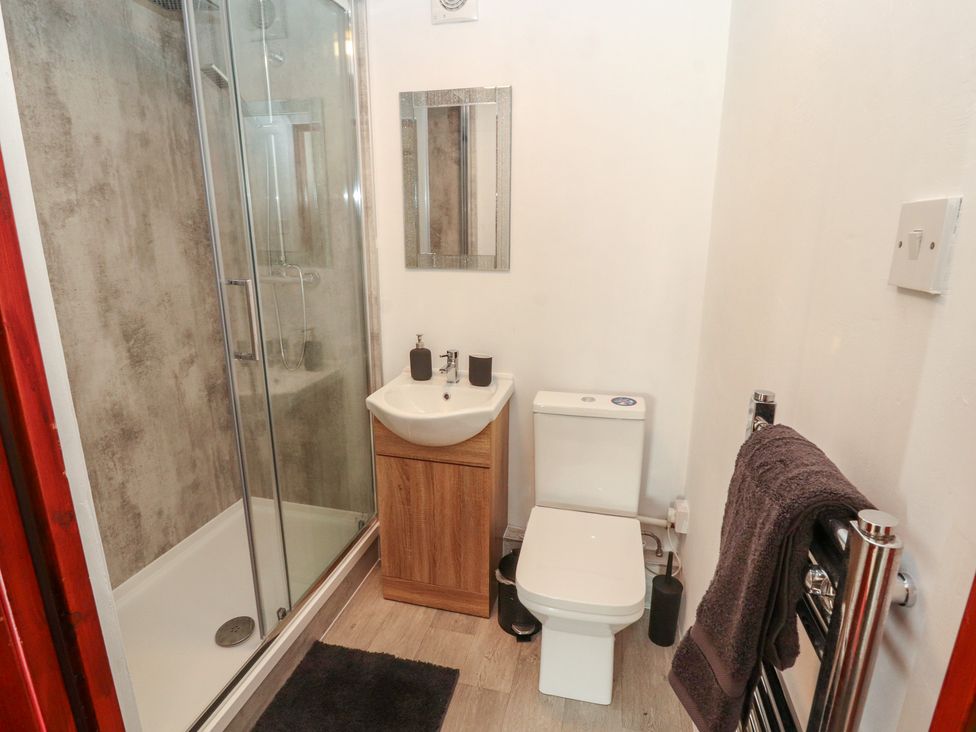 A bathroom with a shower, toilet, and sink at Daisy Cottage Near Wigton