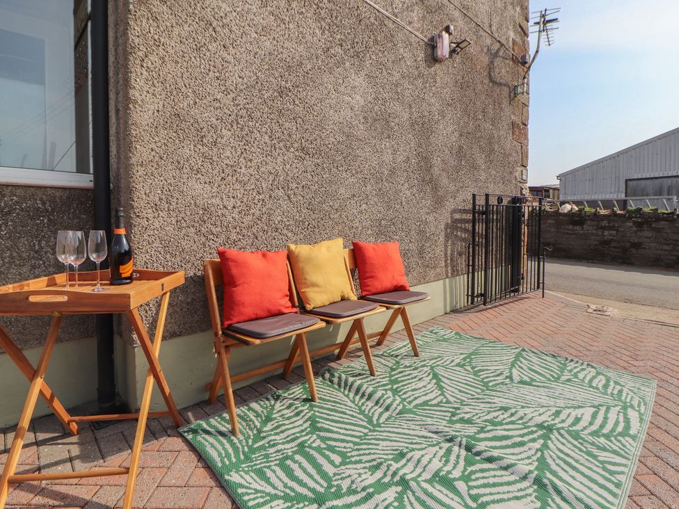 An outdoor seating area with chairs and a table at Daisy Cottage Near Wigton
