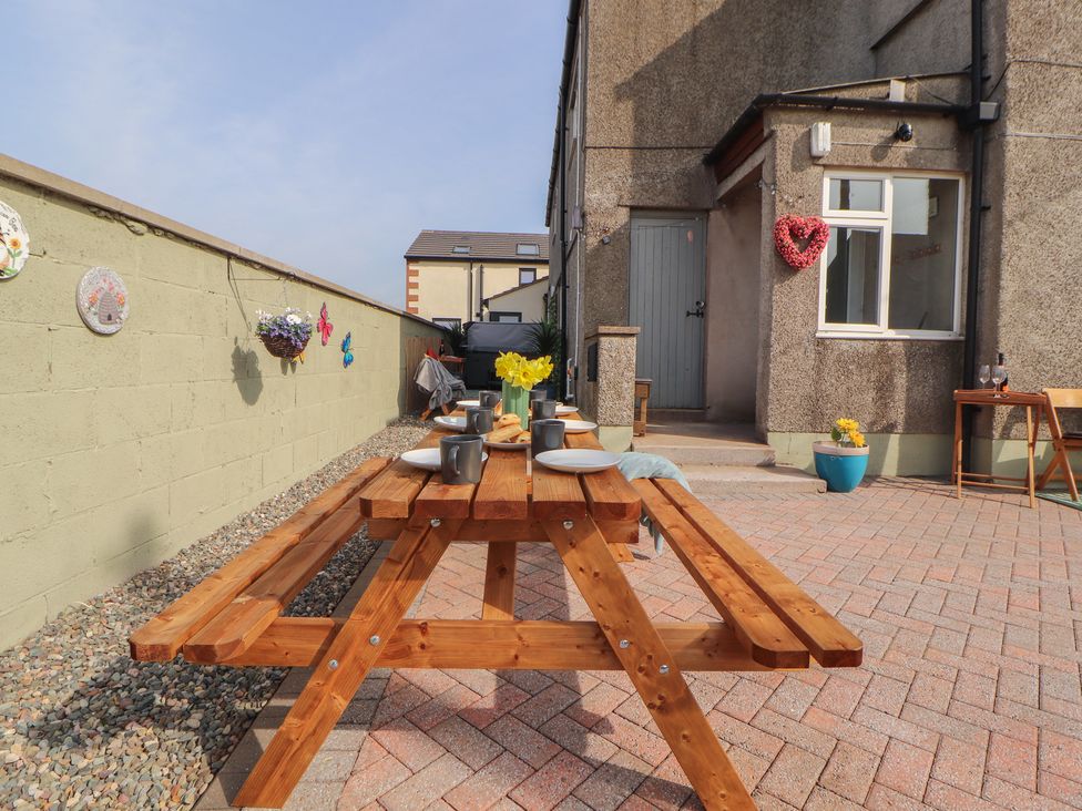 An outdoor area with a picnic table and potted plants at Daisy Cottage near Wigton