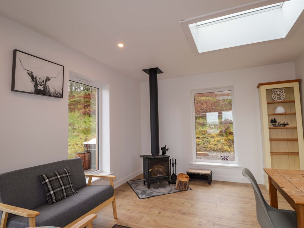 A living room with a stove and sofa at Faodail House in Portree