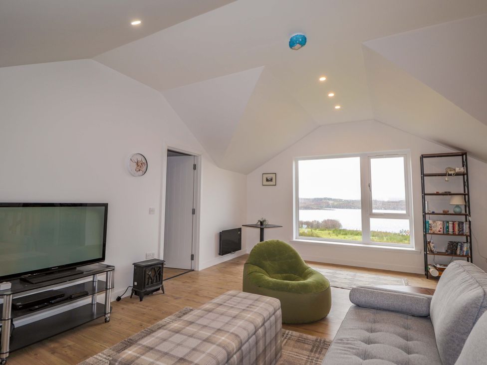 A living room with a television and seating at Faodail House in Portree