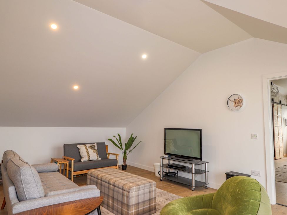A living room with a sofa and television at Faodail House Portree
