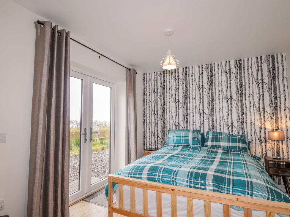 A bedroom with a bed and a window at Faodail House in Portree