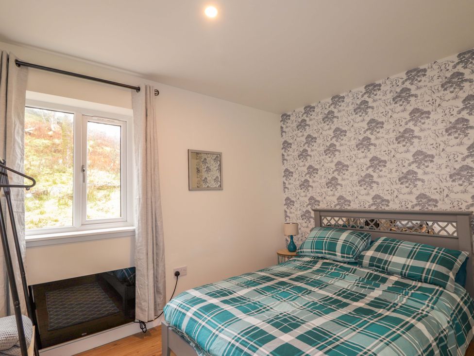 A bedroom with a bed and window at Faodail House in Portree