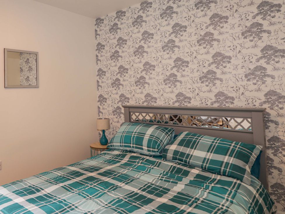 A bedroom with a bed and lamp at Faodail House in Portree