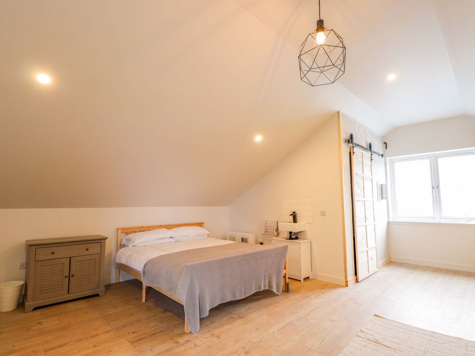 A bedroom with a bed and wardrobe at Faodail House in Portree