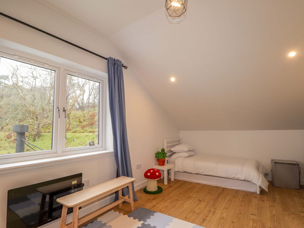 A bedroom with a bed and window at Faodail House in Portree