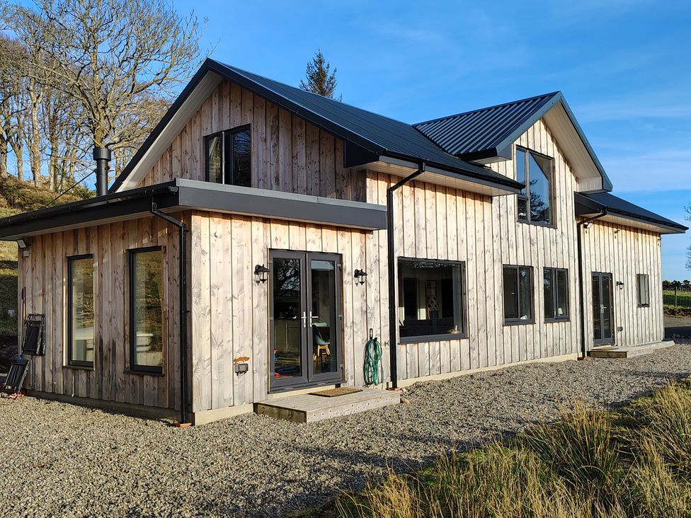 A house with wooden exterior and large windows at Faodail House in Kingsburgh near Uig