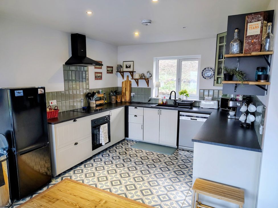 A kitchen with refrigerator and sink at Faodail House in Kingsburgh near Uig