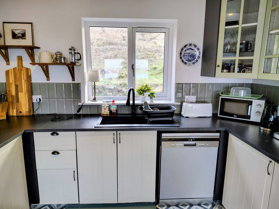 A kitchen with a sink and appliances at Faodail House in Kingsburgh near Uig