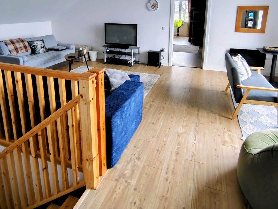A living room with a sofa and television at Faodail House in Kingsburgh near Uig