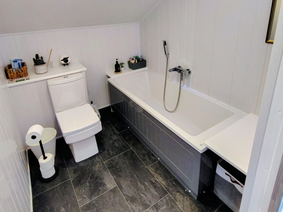 A bathroom with a toilet and bath tub at Faodail House Kingsburgh near Uig