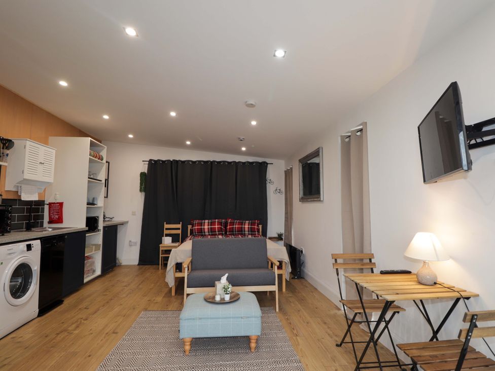 A living room with a sofa and a table at Faodail Studio