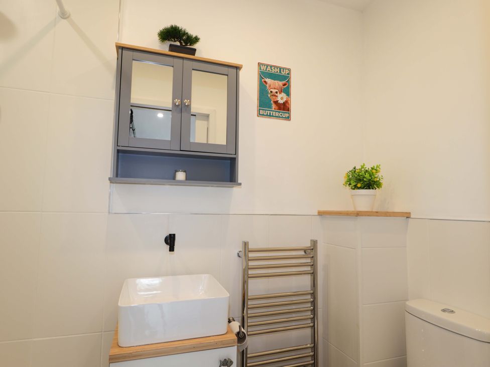 A bathroom with a sink, toilet, and wall cabinet at Faodail Studio 