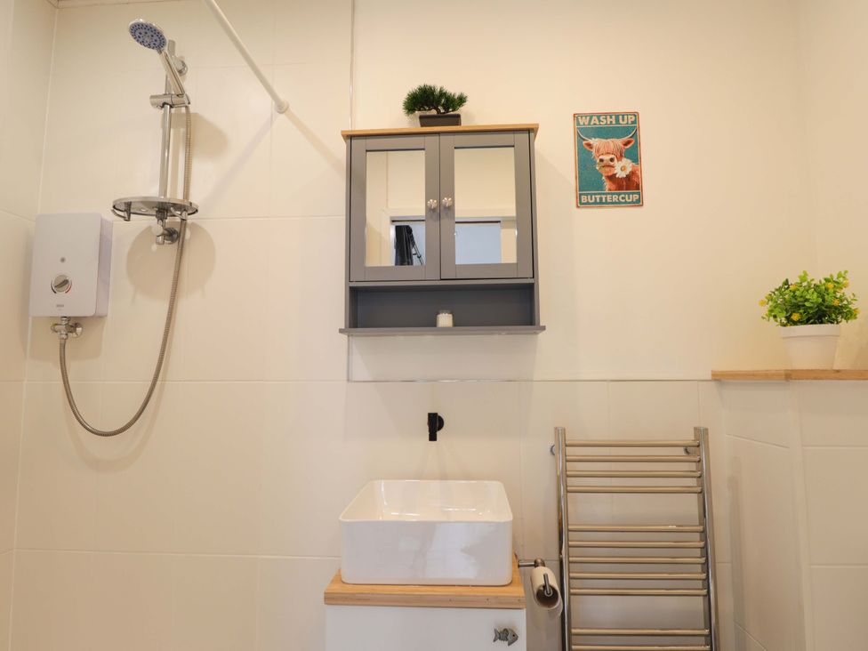 A bathroom with a sink, shower, and wall cabinet at Faodail Studio