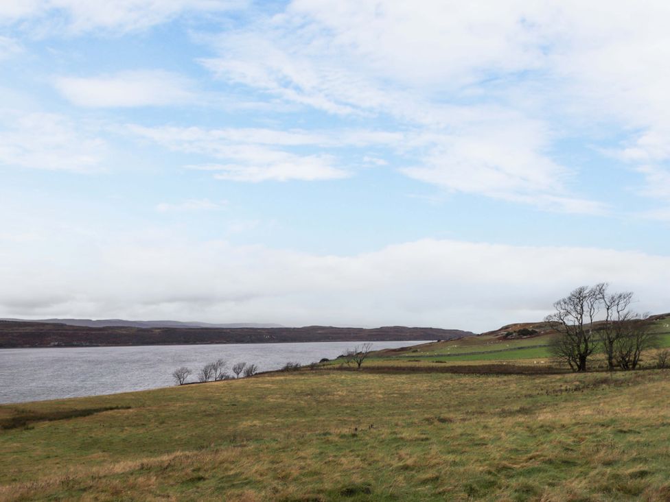 A landscape with grass and water under a blue sky at Faodail Studio